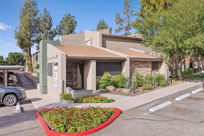 Exterior of the Solaris at Shadow Mountain leasing office with stone accents and landscaping.
