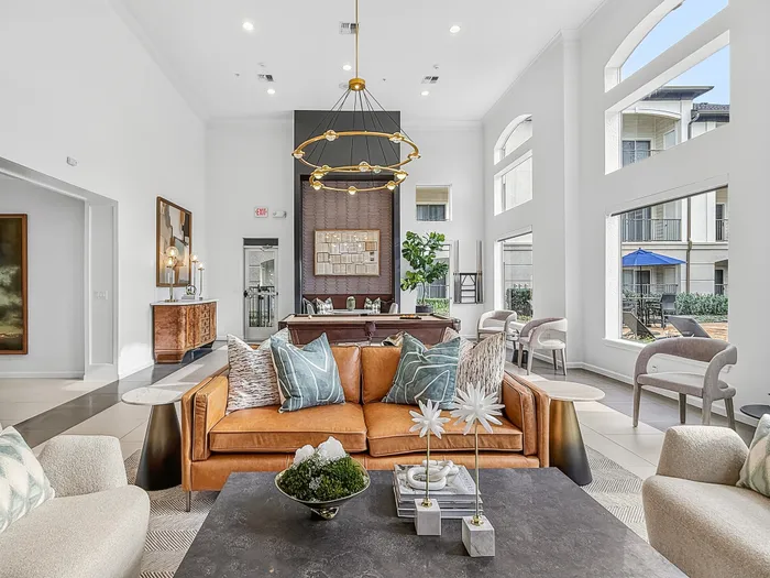 Elegant apartment living area with luxurious furniture, large windows, and sophisticated decor, exuding warmth and modern comfort.