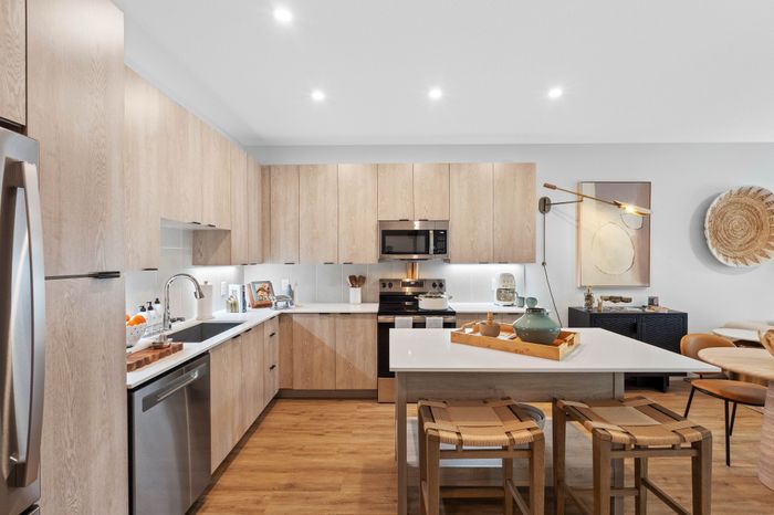 Modern kitchen with wood cabinetry, stainless steel appliances, and stylish accents, creating an inviting and functional space.