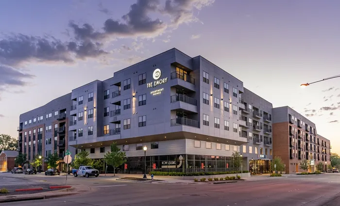 Modern apartment complex at dusk featuring contemporary architecture and elegant lighting, perfect for urban living.