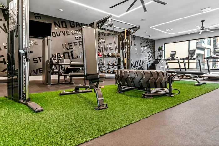 Modern fitness center with state-of-the-art equipment, featuring sleek weight machines, treadmills, and motivational wall decor.