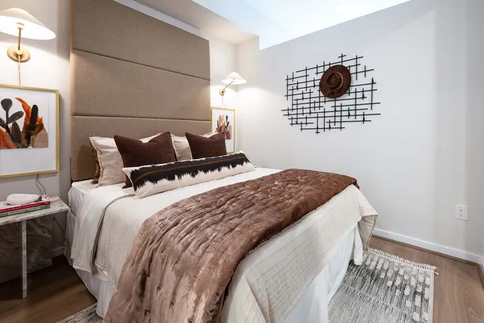 Elegant bedroom showcasing a luxurious bed with plush pillows, stylish wall art, and a cozy ambiance.