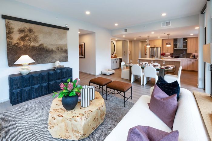 Elegant open-plan living space showcasing a modern kitchen and dining area with chic decor and ample natural light.