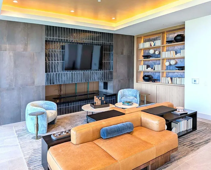 Luxurious living room featuring a chic leather sofa, modern built-in shelving, and a sleek entertainment center with a mounted TV.