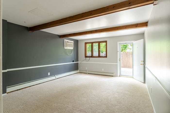 spacious carpeted back room leading to outdoor patio