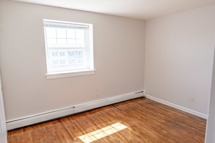 bedroom with window and wood floor