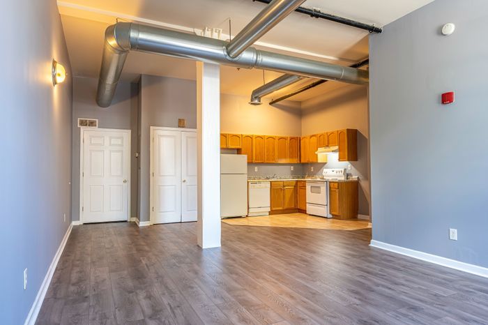 spacious room with high ceilings and attached kitchen