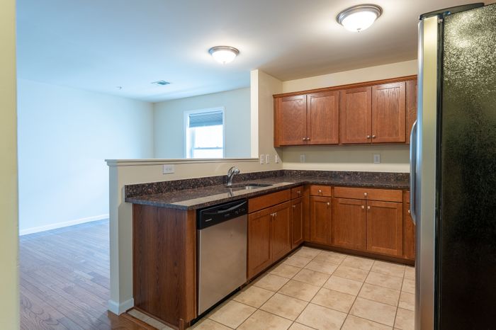 kitchen with tile floor and lots of cabinets and counter space, looking over half wall to room