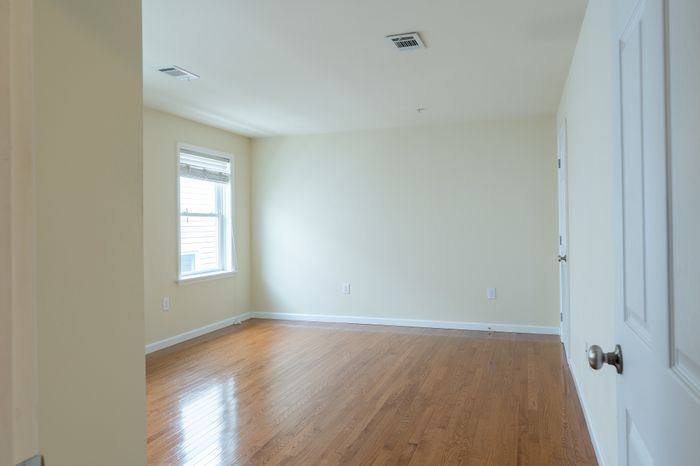 bedroom with windows and wood floor