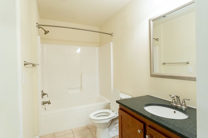 full bathroom with cabinets under sink