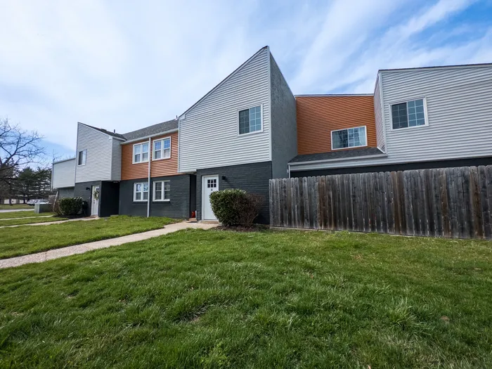 405 at Main Apartments exterior showing townhouse-style units, grassy lawn and paved walkways in Collegeville, PA.