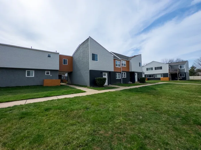 405 at Main Apartments exterior showing lawn, sidewalks, and townhouse-style units.