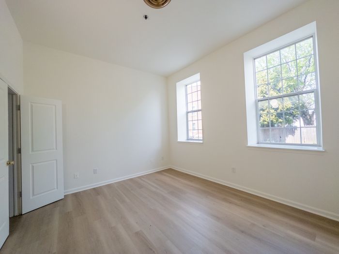 bedroom with vinyl plank floors and large windows