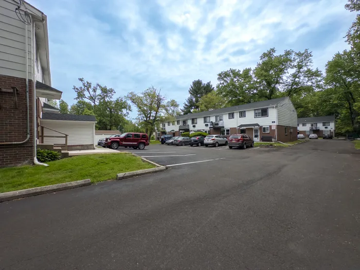 Parking area and two-story brick-and-siding apartment buildings at Woodland Manor Apartments, Morrisville, PA.