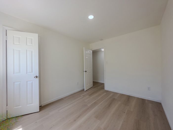 bedroom with closet, luxury vinyl flooring, door leading to hallway