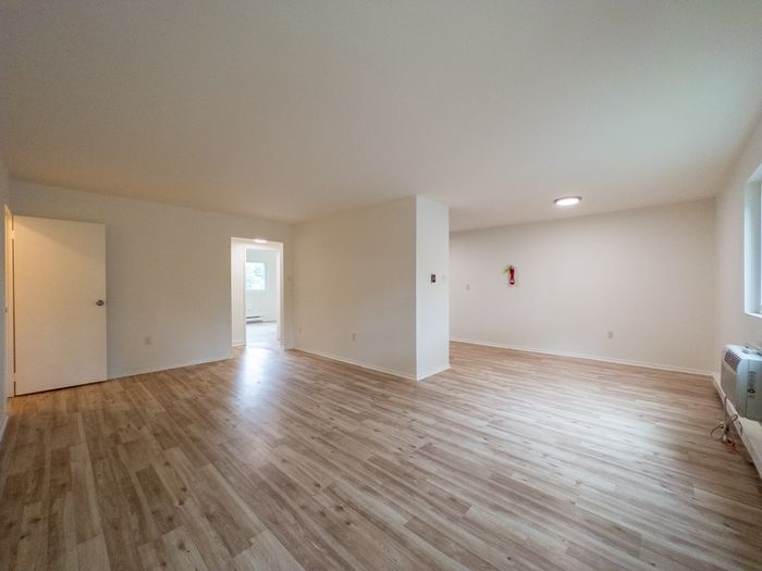 Spacious open living area with light wood laminate floors and white walls in Laureldale, PA.