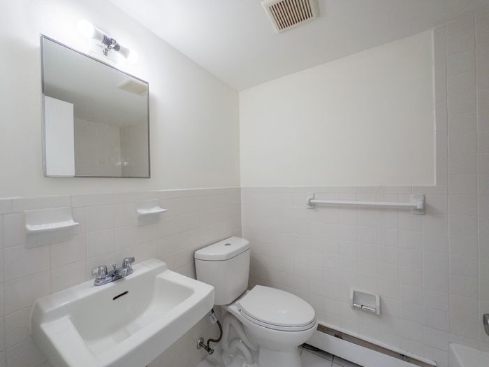 bathroom with tiled wall, energy efficient toilet