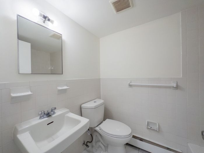 bathroom with tiled wall, energy efficient toilet