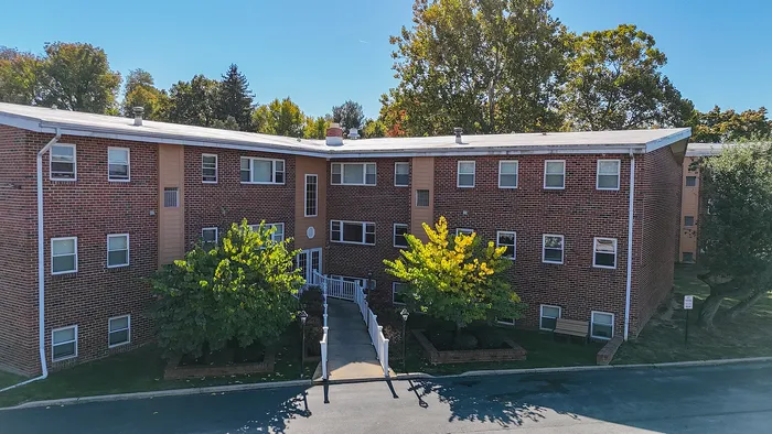 springfield valley apartments exterior, shaded entrance with concrete walkway and railings, light posts, trees