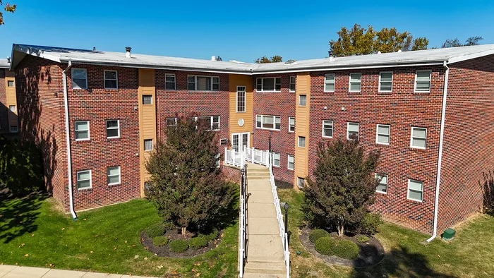 springfield valley apartments exterior, large brick building surrounded by landscaped grounds, concrete walkway to entrance