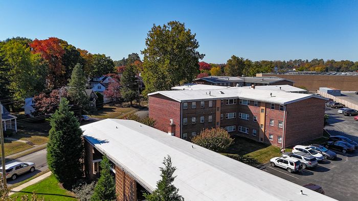 springfield valley apartments aerial view, resident parking lot behind brick buildings, landscaped grounds, colorful trees