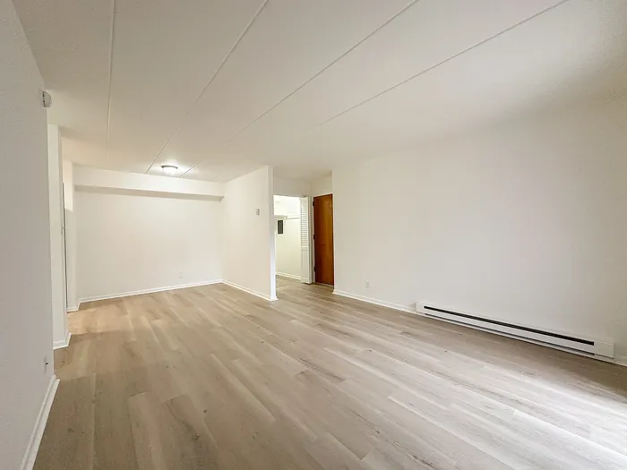 Bright and spacious living area with elegant wood flooring and ample natural light, perfect for a modern lifestyle.