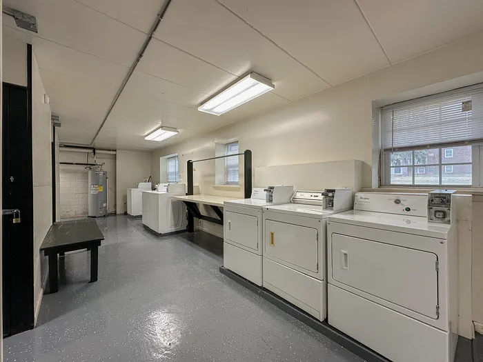 Spacious and bright laundry room equipped with modern washers and dryers, enhancing convenience and comfort in your new home.