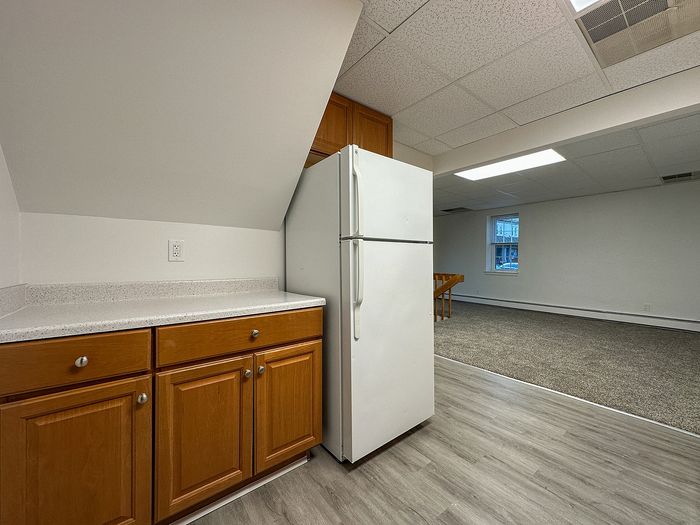 Modern apartment kitchen with sleek countertops, warm wood cabinetry, and spacious open-plan design.