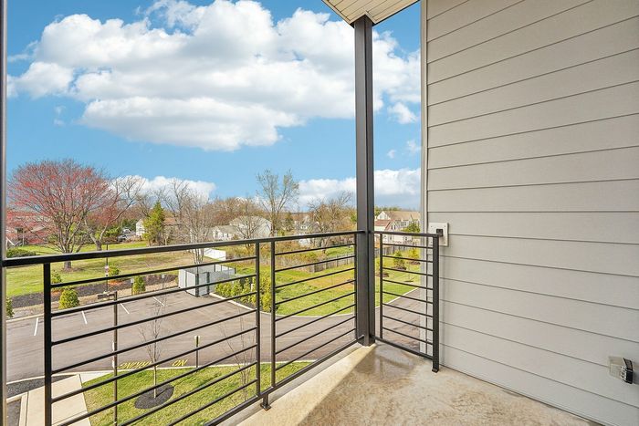 Charming balcony view showcasing a scenic neighborhood with lush greenery and tranquil skies.