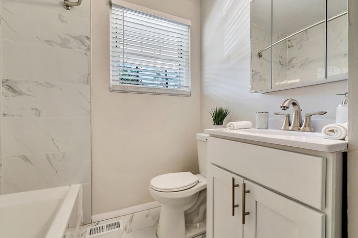 Elegant bathroom with marble tile, modern fixtures, and natural light.
