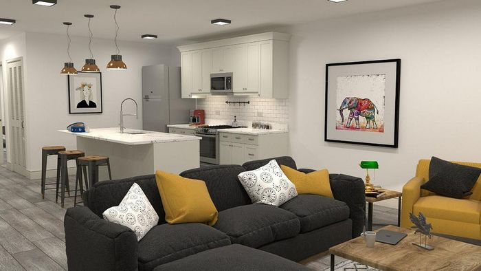 Modern open-concept living space with cozy dark sofas, vibrant yellow accents, chic kitchen island, and stylish pendant lighting.
