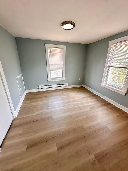 Inviting room with modern lighting, hardwood floors, and large windows for natural light.