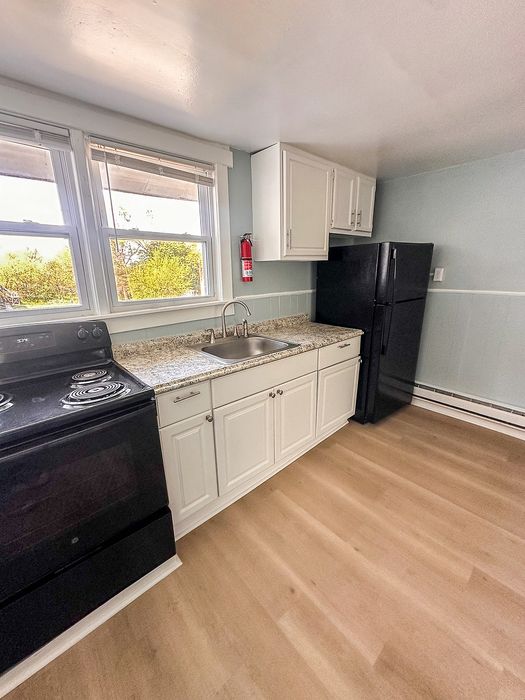 Bright, modern kitchen with sleek granite countertops, elegant white cabinetry, and a spacious layout.