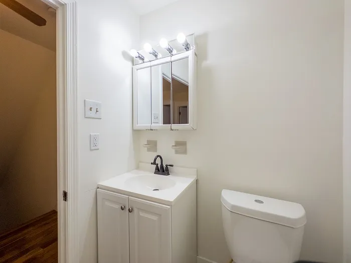 Bright, modern bathroom with sleek vanity, ample lighting, and contemporary fixtures.