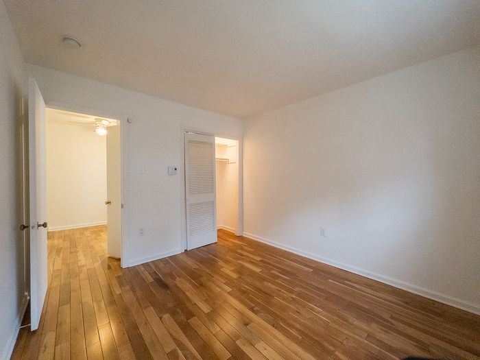 Inviting room with elegant wooden floors and ample closet space, perfect for creating a cozy living environment.