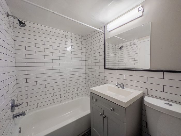 Sleek modern bathroom with subway tile walls, elegant vanity, and cozy ambiance.