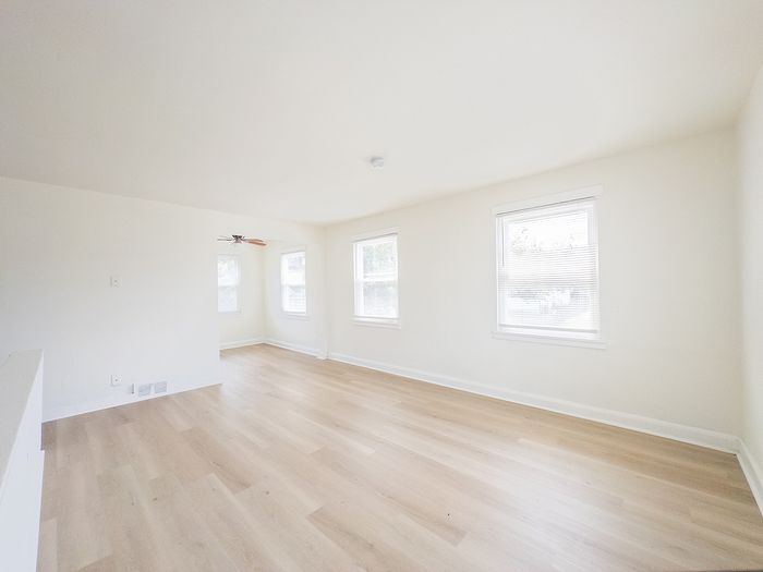 Bright and airy living space with expansive windows, fresh white walls, and elegant hardwood flooring.