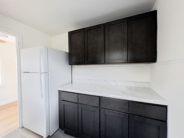 Chic kitchen with sleek dark cabinets, modern appliances, and elegant marble countertops.