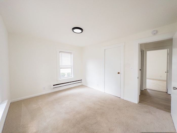 Bright and airy bedroom with plush carpeting and modern fixtures, offering a serene retreat.