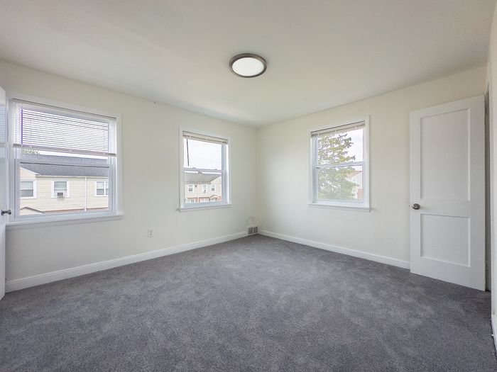 Bright and airy bedroom with plush carpeting and large windows offering abundant natural light.