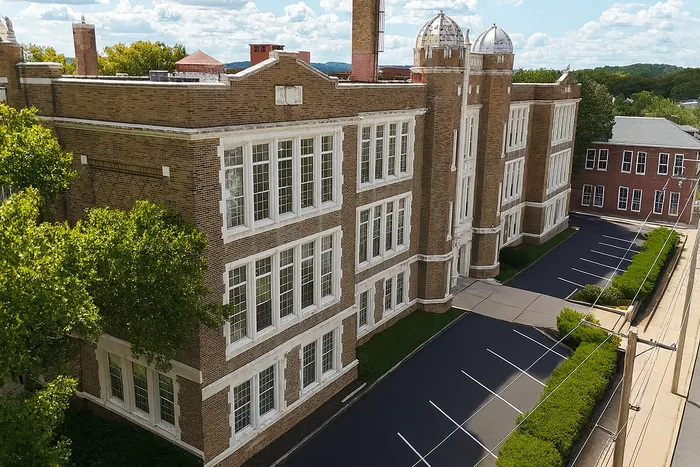 Franklin Manor Apartments, historic brick three-story building with tall multi-pane windows and parking lot in West Reading PA.