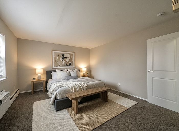 Cozy and elegant bedroom with stylish decor, featuring a plush double bed, warm lighting, and tasteful artwork.