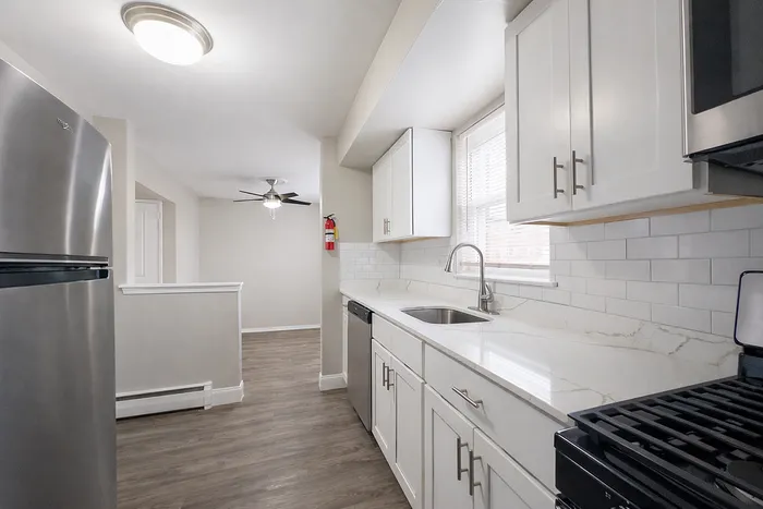Bright and modern kitchen with sleek stainless steel appliances, elegant white cabinetry, and a stylish tile backsplash.