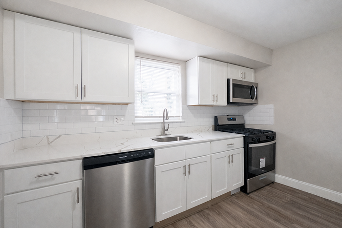 Bright and modern kitchen with stainless steel appliances, sleek white cabinetry, and elegant subway tile backsplash.