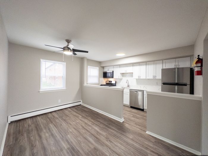 Modern apartment kitchen with sleek stainless steel appliances, elegant white cabinetry, and a spacious layout for seamless cooking and dining.
