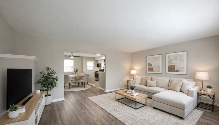 Bright, contemporary living space featuring an elegant open floor plan with plush seating, modern decor, and a stylish dining area adjacent to a sleek kitchen.