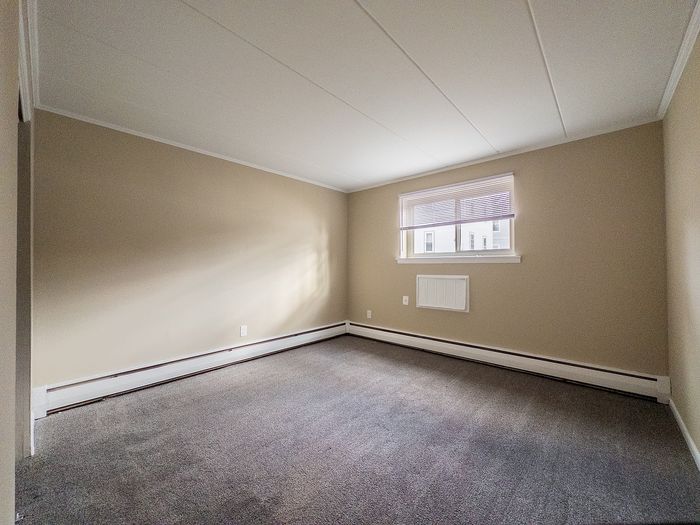 Bright, spacious room with neutral tones and natural light, perfect as a versatile living or bedroom space.