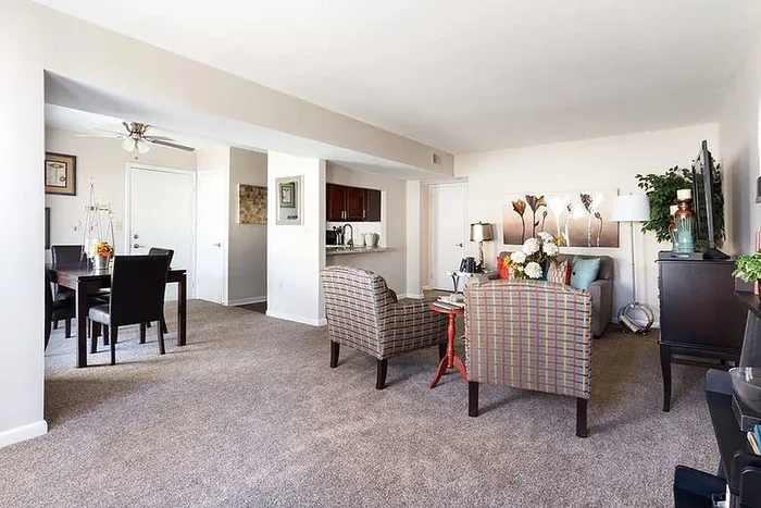 Bright and inviting living area seamlessly connected to a dining space, featuring cozy seating, elegant decor, and natural light.