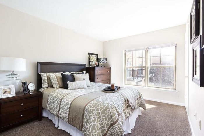 Inviting bedroom with elegant decor, large sunlit window, and comfortable bedding for a cozy retreat.