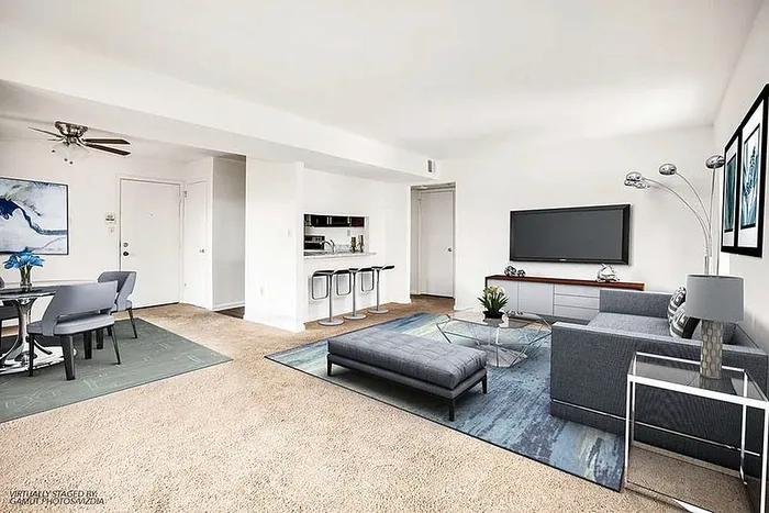 Elegant open-plan living room with modern furniture, cozy dining area, and stylish breakfast bar in a bright, airy apartment.